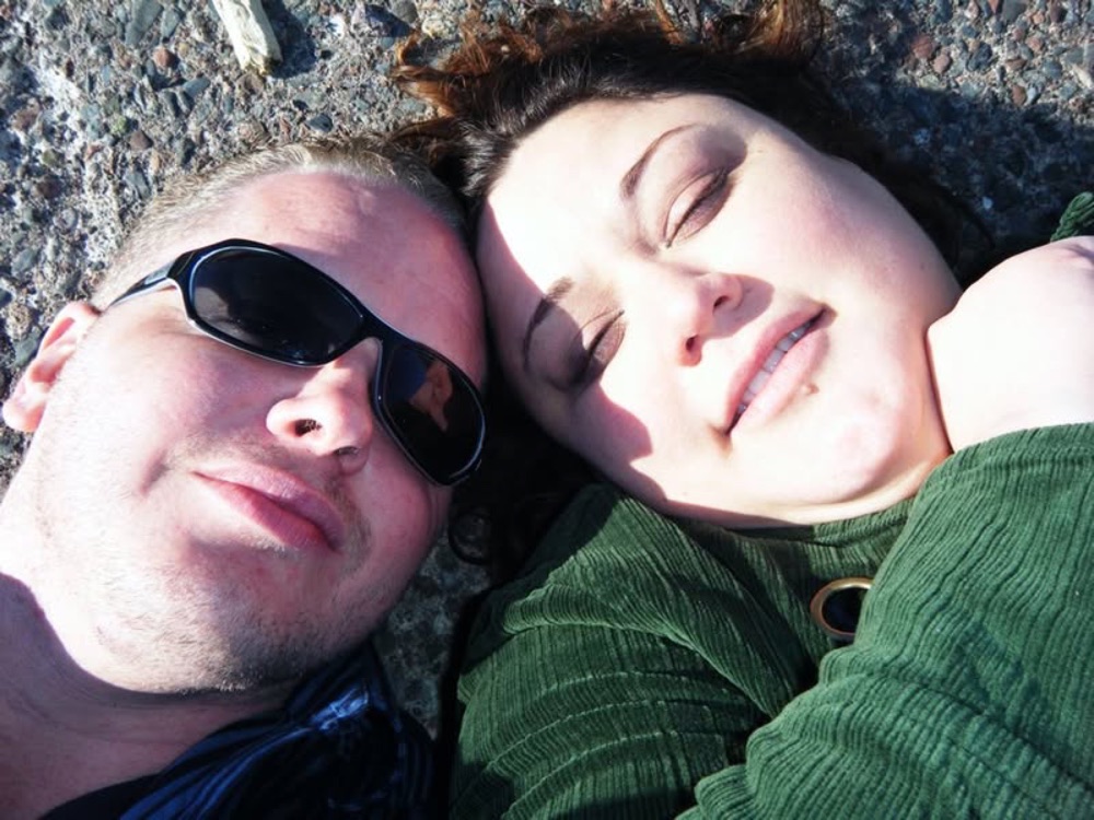 Faye and Jim lying in the sun with their heads together