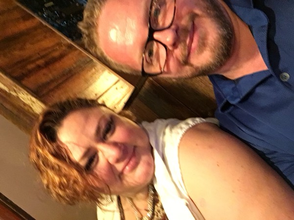 Cozy selfie of Faye and Jim by a barn-wood wall